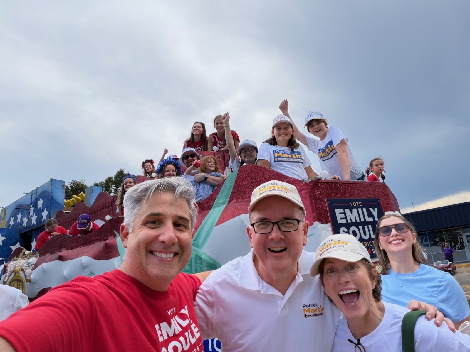 Patrick Martin and his campaign krewe pose in front of the red-white-and-blue flag float outside McKinley High School.