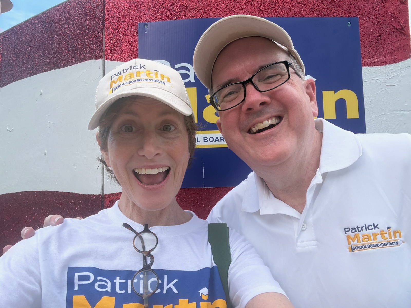 Patrick Martin and his wife Wendy smile for a selfie in front of a Patrick Martin campaign banner.